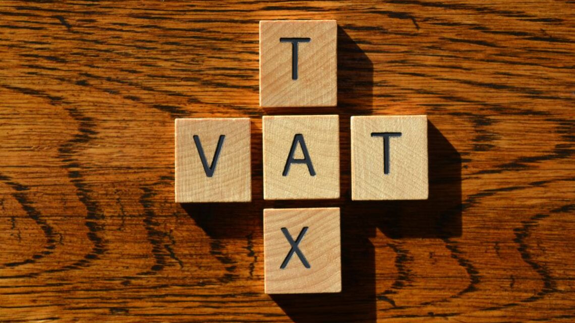 VAT and Tax, words in wooden alphabet letters isolated on wood background