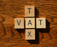 VAT and Tax, words in wooden alphabet letters isolated on wood background